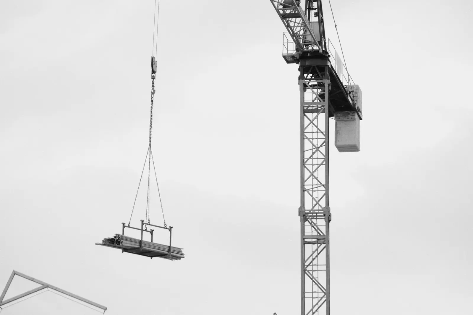 Tower crane lifting heavy load over city